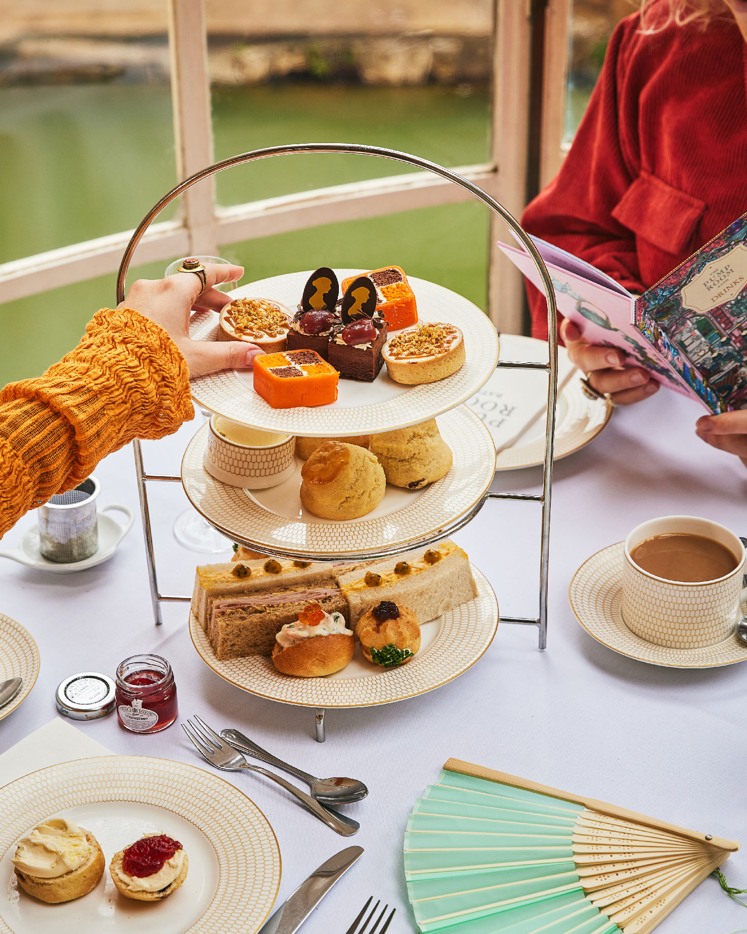 Afternoon tea is served in the Pump Room; a hand reaches out to nibble a delicious selection of cakes, pastries, scones and savoury bites